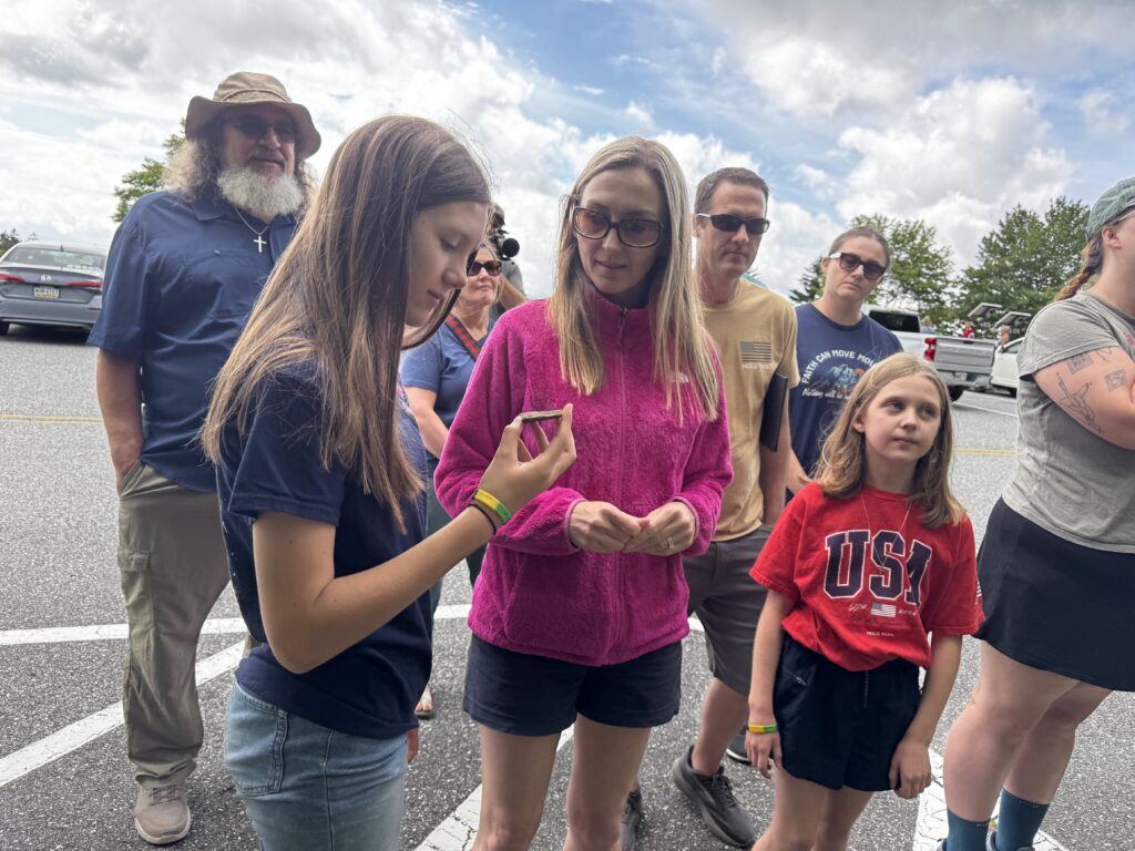 Tour guests examining a small rock sample during a Canyon Ministries creation tour in Great Smoky Mountains National Park