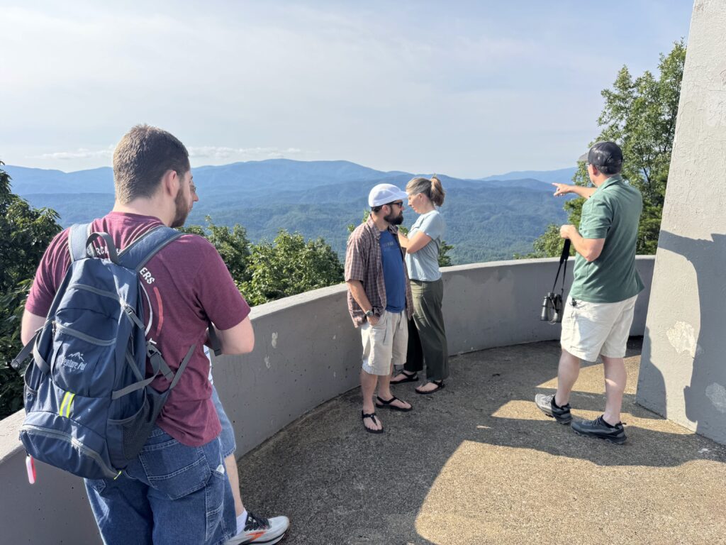 Adam Huff of Canyon Ministries pointing across forested ridges from an overlook in Great Smoky Mountains National Park