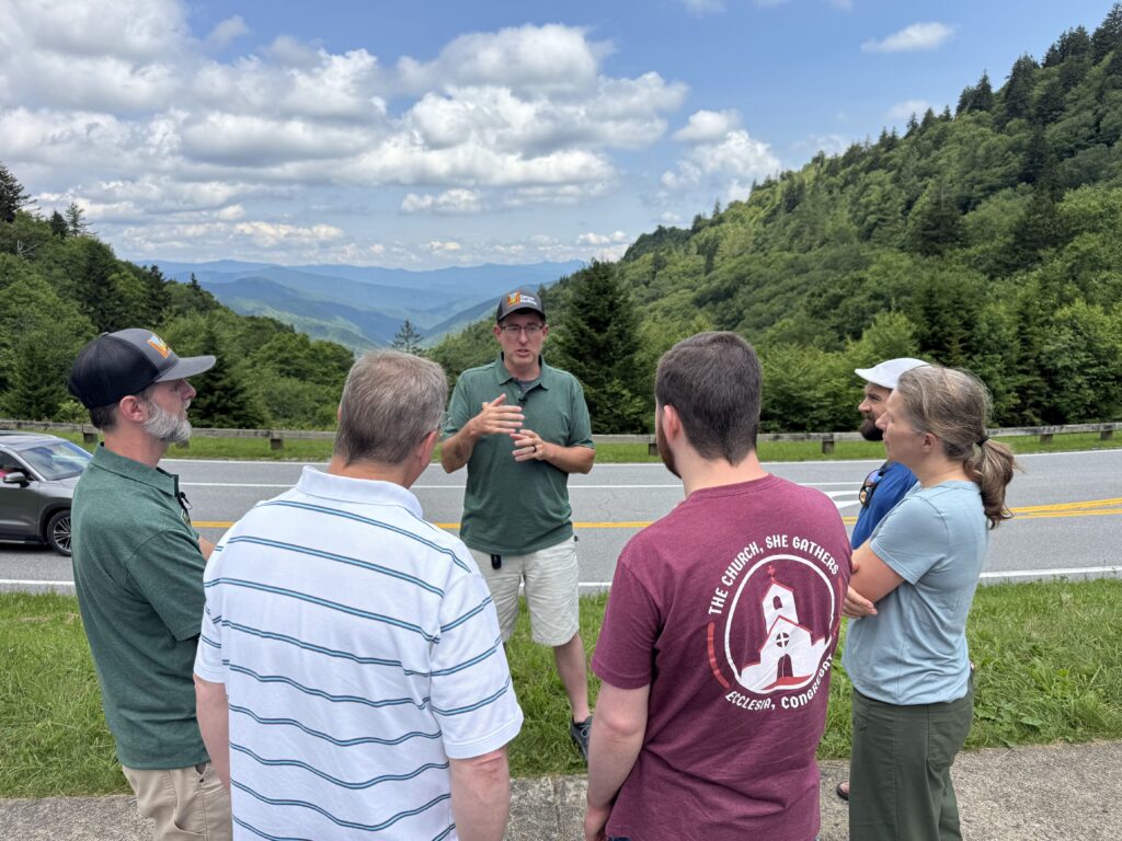Luke Wayne and Adam Huff of Canyon Ministries teaching guests beside a mountain road and forested valley in Great Smoky Mountains National Park